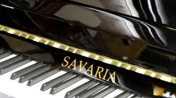 Gros plan sur un piano Savaria noir on voit le logo et le clavier